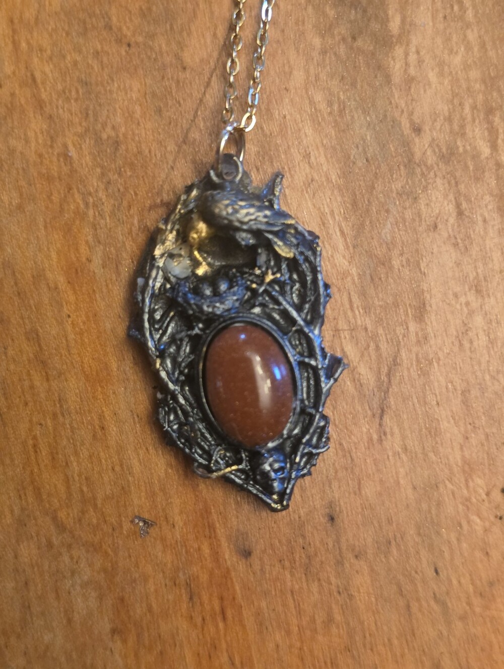 Resin Raven Frame Above A Copper Gemstone On A Gold-Tone Chain Necklace